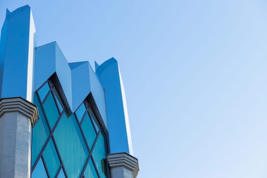 From below of entrance of office building next to contemporary high rise structures with glass mirrored walls