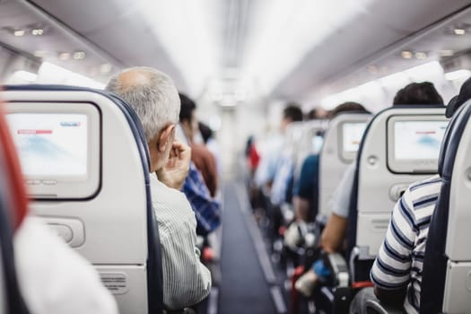 Interior of airplane with passengers on seats waiting to taik off.