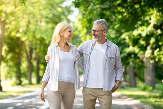 Portrait Of Beautiful Older Couple Walking Together In Summer Park, Romantic Senior Spouses Embracing And Looking At Each Other, Smiling Mature Man And Woman Enjoying Outdoor Date, Copy Space