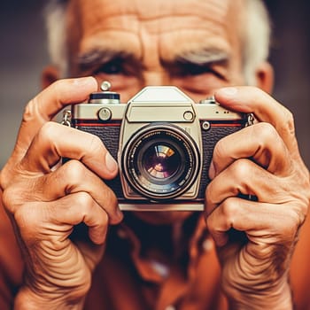A pensioner takes photographs with an old camera. High quality photo