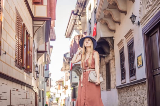 Happy woman tourist on background of old street of Antalya. female tourist traveler discover interesting places and popular attractions and walks in the old city Kalechi of Antalya, Turkey. Turkiye.