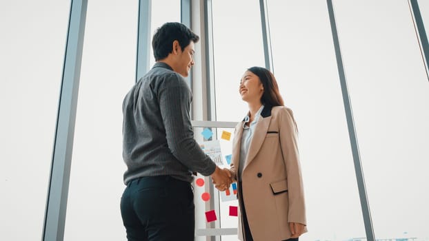 Business people handshake in corporate office showing professional agreement on a financial deal contract. Jivy