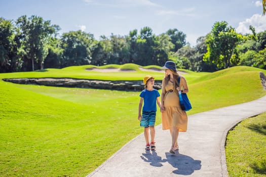 Expectant mother and her son enjoying a leisurely stroll in the park, cherishing precious moments amidst nature's beauty.