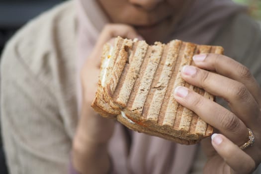 women hand pick Sandwich with ham, cheese, tomatoes,