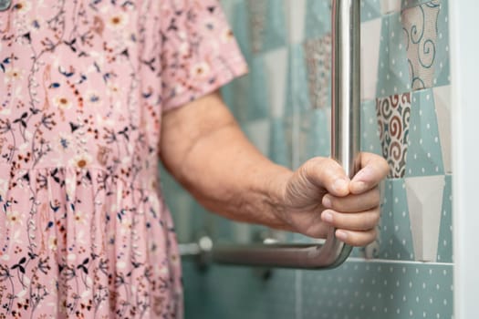 Asian elderly woman patient use toilet bathroom handle security in nursing hospital, healthy strong medical concept.