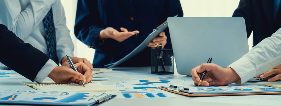 Business people in group meeting in formal attire share idea discussing report for company profit in creative workspace for start up business shot in close up view on group meeting table . Oratory .