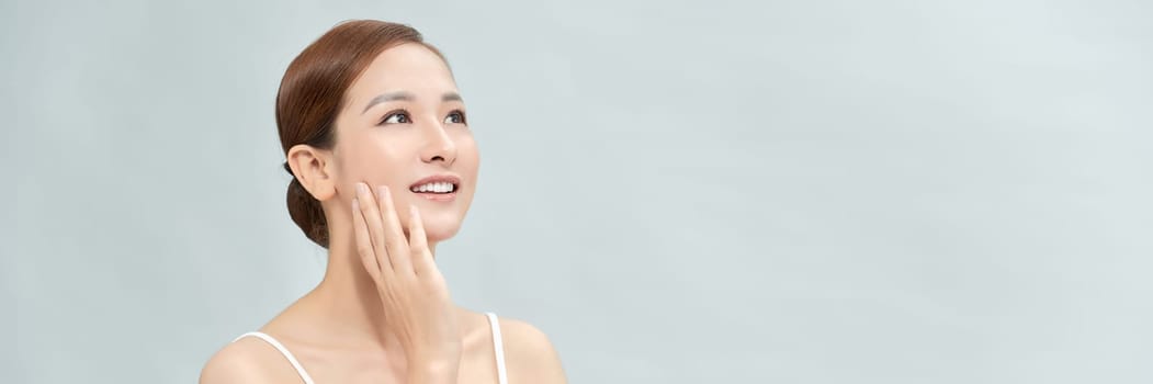 Asian woman has a lovely face is feeling happy with her perfect skin touch her face. Banner
