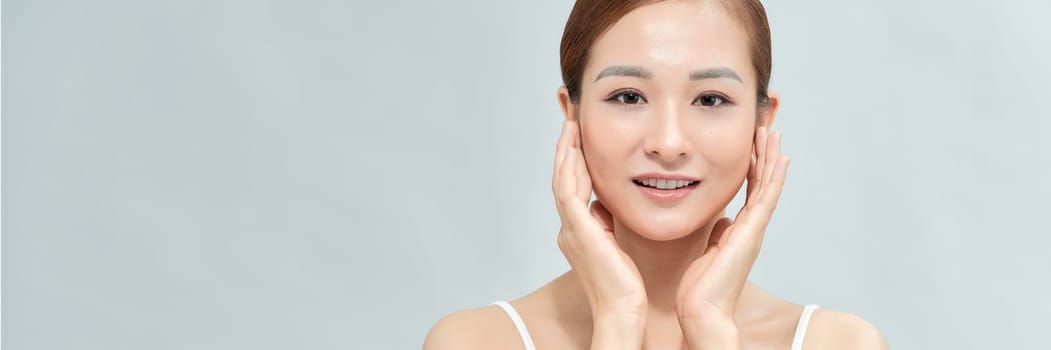 Asian woman has a lovely face is feeling happy with her perfect skin touch her face. Banner