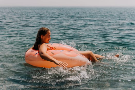 Summer Vacation Woman in hat floats on an inflatable donut mattress, a water toy swim ring. Unrecognizable young woman relaxing and enjoying family summer travel holidays vacation on the sea