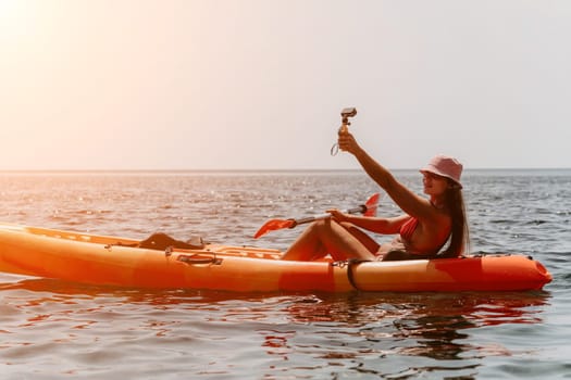Happy smiling woman in kayak on ocean, paddling with wooden oar. Calm sea water and horizon in background