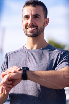Young athletic sportswoman with a smartwatch looking at camera