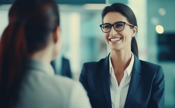 Happy two business people discussing a new project together in an office, professionals smiling colleagues women having a conversation at a meeting