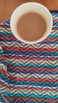 coffee in a glass, colorful towels background, ornament texture, drink. High quality photo