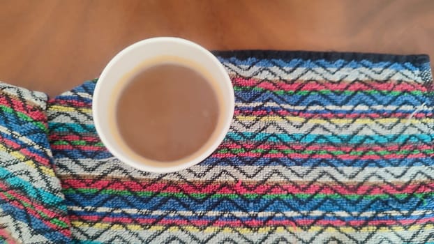 coffee in a glass, colorful towels background, ornament texture, drink. High quality photo