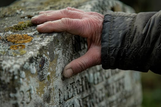 Hand Touching Engraved Headstone, Symbol of Time and Remembrance, Contemplating Memories.
