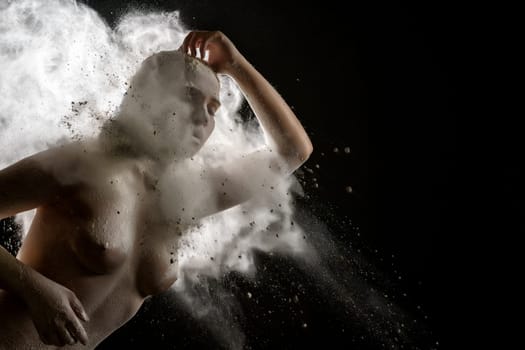 Young model topless in a cloud of white dust studio shot
