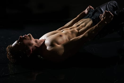 Athletic young man in jeans and with naked torso taking shower studio portrait