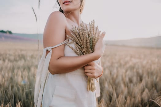 A woman in a white dress holds a bouquet of wheat stalks in a field of grain.
