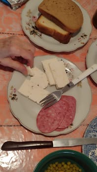 bread sausage and cheese, woman's hand, food carbohydrates breakfast, food products. High quality photo