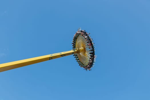 Helsinki, Finland - 19 July 2024: Linnanmaki Amusement Park, new roller coaster Swingi in motion, blue sky on a background, happy people