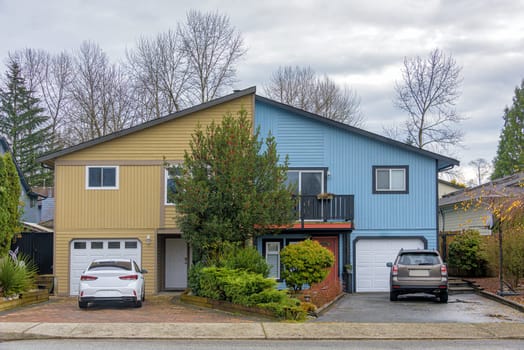 Duplex residential house with cars parked in front on autumn season in British Columbia.