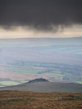View down to Brats Tor with Widgery Cross on top under dark storm clouds, Dartmoor National Park, Devon, UK