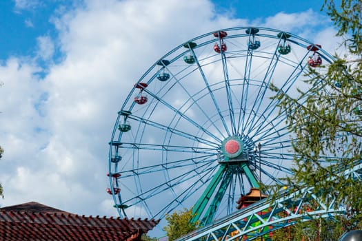 Helsinki, Finland - 19 AUGUST 2024: Linnanmaki amusement park. Ferris wheel Rinkeli, blue sky on a background