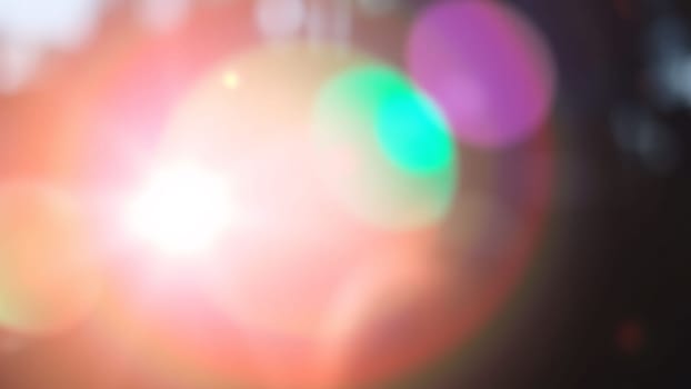 Light pours from a warm, bright rainbow in blur on a black background with a dusty texture. Use this defocused, abstract, damaged, scratched, retro cinema analog effect as a screen filter or overlay for image. High quality photo