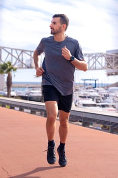 A photo of a young runner training with headphones on the city streets outdoors