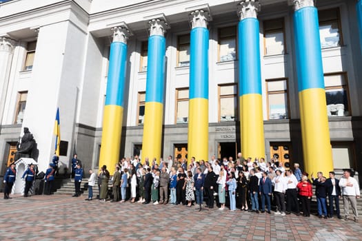 KYIV, UKRAINE - Aug. 23, 2024: A solemn ceremony near the Verkhovna Rada on State Flag Day. A group of parliamentarians during the ceremonial raising of the Ukrainian national flag