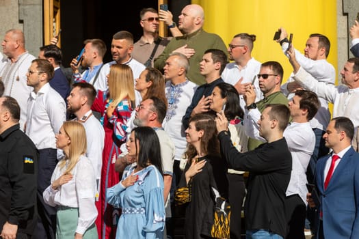 KYIV, UKRAINE - Aug. 23, 2024: A solemn ceremony near the Verkhovna Rada on State Flag Day. A group of people's deputies during the flag-raising ceremony and singing of the national anthem