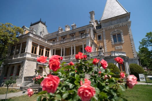 A large building with a lot of windows and a balcony. The balcony is covered with red roses