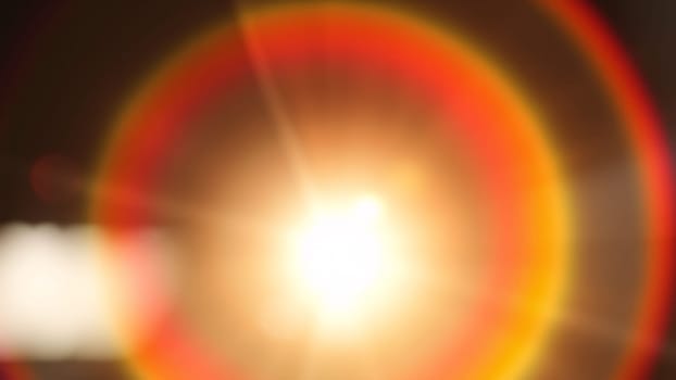 Light pours from a warm, bright rainbow in blur on a black background with a dusty texture. Use this defocused, abstract, damaged, scratched, retro cinema analog effect as a screen filter or overlay for image. High quality photo