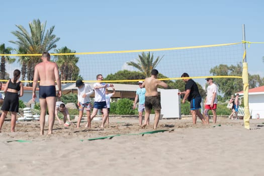 vacationing tourists of different ethnic groups play beach volleyball together on the beach by the sea during vacation, throw the ball over the net,Green Max Hotel, Belek, Turkey, May 29, 2024