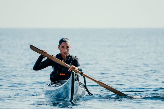 Happy smiling woman in kayak on ocean, paddling with wooden oar. Calm sea water and horizon in background