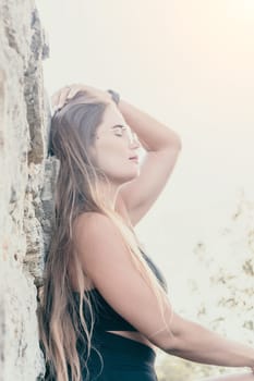 Woman travel sea. Young Happy woman in a long red dress posing on a beach near the sea on background of volcanic rocks, like in Iceland, sharing travel adventure journey
