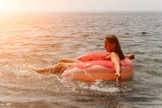 Summer Vacation Woman in hat floats on an inflatable donut mattress, a water toy swim ring. Unrecognizable young woman relaxing and enjoying family summer travel holidays vacation on the sea
