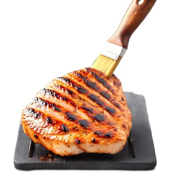 Juicy barbecued chicken breast with charred grill marks and a basting brush Summer food concept. close-up food, isolated on transparent background