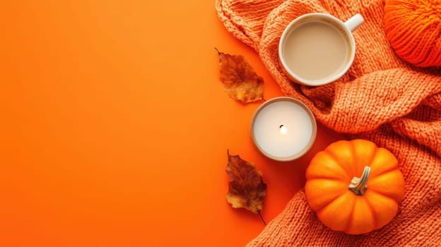 A cup of steaming coffee sits beside a lit candle, surrounded by a pumpkin and autumn leaves atop a soft knit scarf against an orange backdrop.