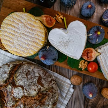 Selection of French cheeses from Normandy, AOP, Livarot, Neufchatel, Pont l'eveque, Rye bread, figs, walnuts, grapes, elderberry gelee. High quality photo