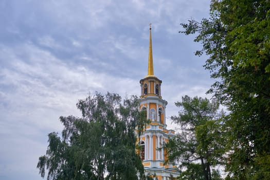A tall bell tower with a gilded spire. Old Russian architecture