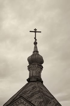 Orthodox cross on top of church. Monochrome image with sepia effect