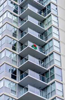 Corner of a residential high-rise building with balconies decorated for Christmas celebration