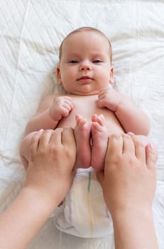 Mother's hands work on baby's feet. Concept of healing touch for colic relief