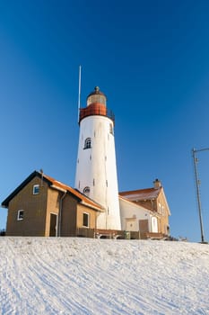 Lighthouse of Urk Netherlands during winter with snow in the Netherlands with a blue sky
