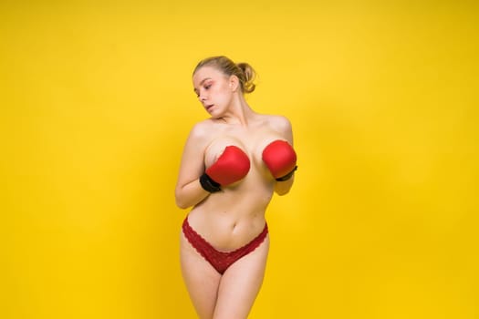 A beautiful, attractive, seductive girl with blonde hair in a studio.