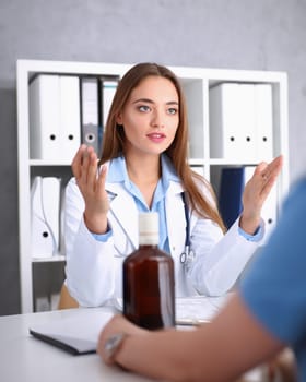 Beautiful female doctor and sleepy alcoholic at reception in office portrait. Grief and despair of intoxicated for sober life change drunkenness bad habit lifestyle dependence and temperance concept