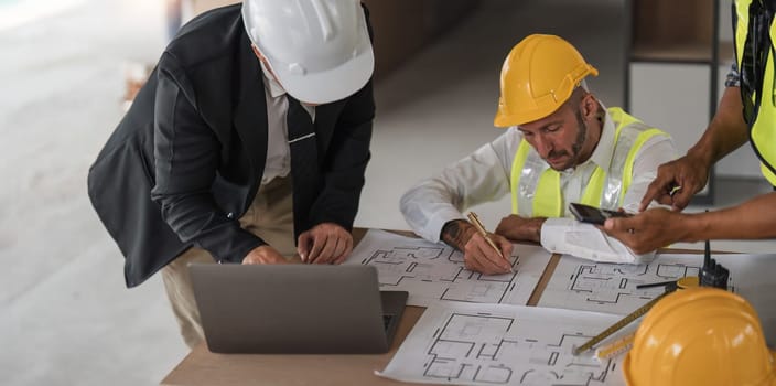 Civil engineer teams meeting working together wear worker helmets hardhat on construction site in modern city. Foreman industry project manager engineer teamwork. Asian industry professional team