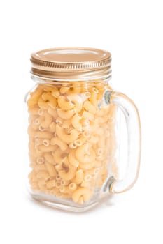 Uncooked Chifferi Rigati Pasta in Glass Jar Isolated on White Background. Fat and Unhealthy Food. Classic Dry Macaroni. Italian Culture and Cuisine. Raw Pasta - Isolation