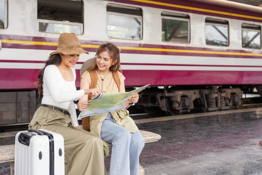 Travel concept. girl friend wear hat holding map have bag and luggage. female traveller waiting train at train station.